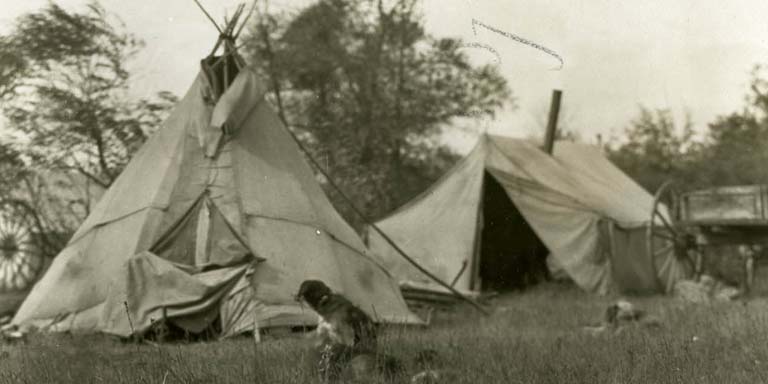 Black and white photo of two canvas teepees