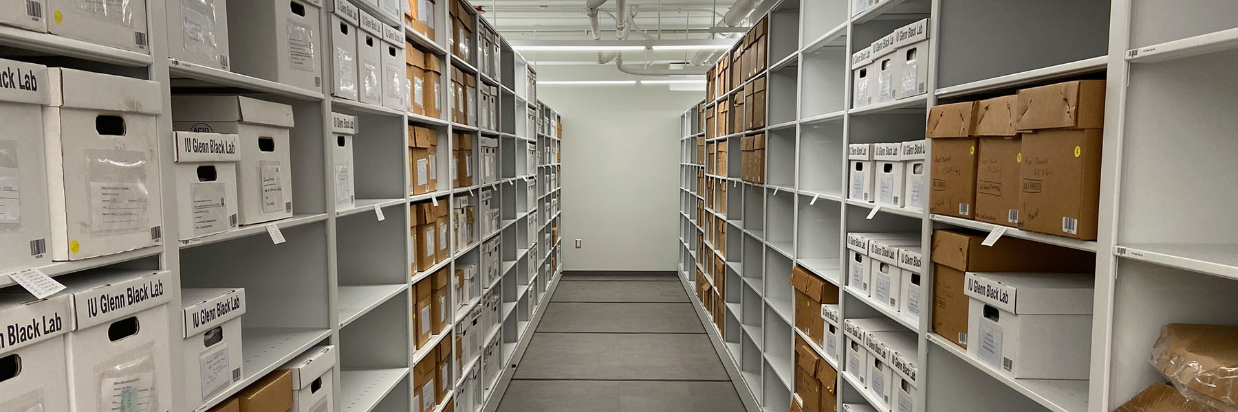 A view of a set of shelves filled with white and brown labeled boxes 