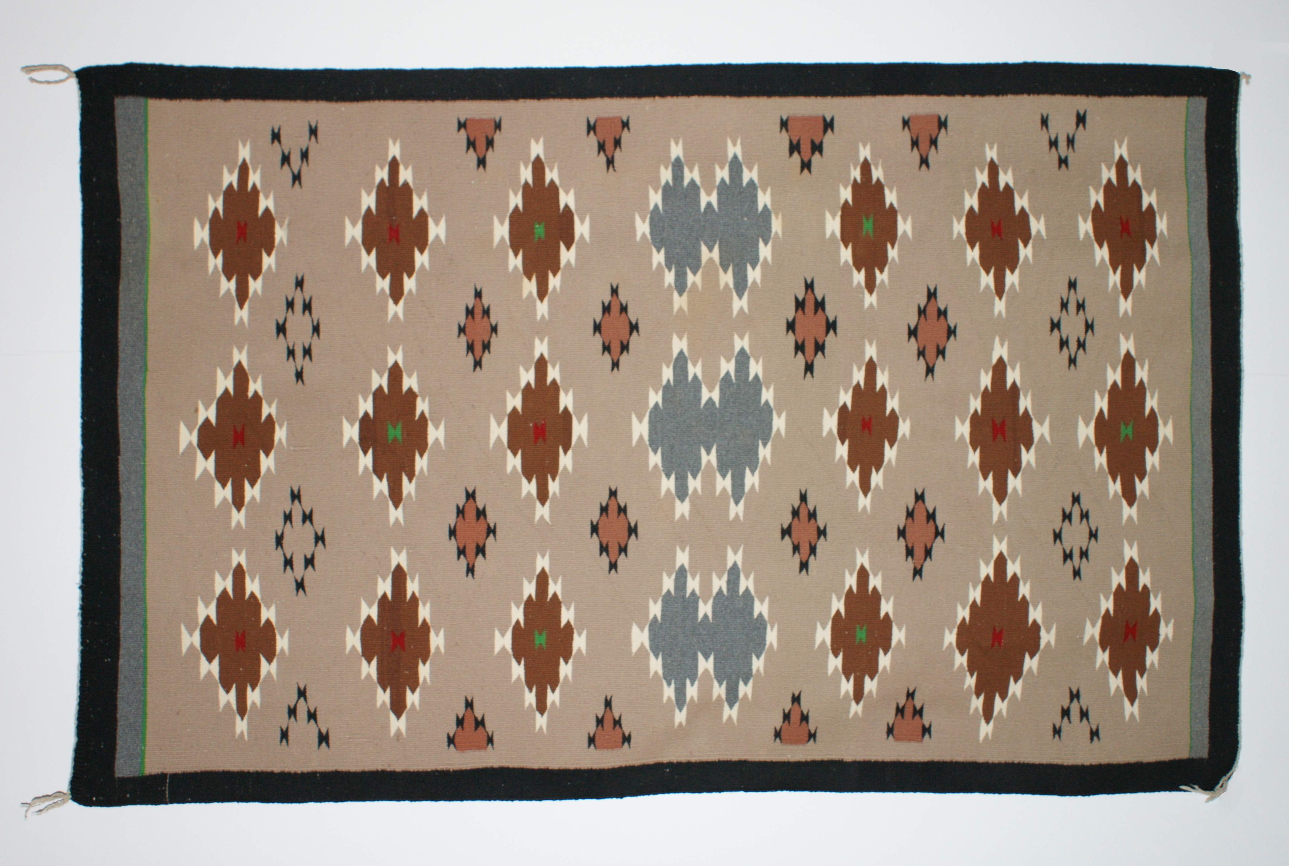 Image of woven rug, with multicolored diamond designs.